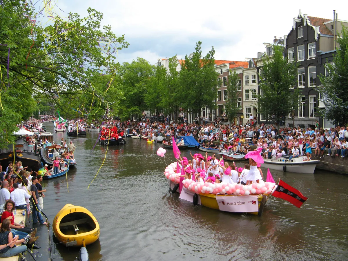 A decorated boat and crowded canal during the Amsterdam Pride Canal Parade Canal Parade in Amsterdam